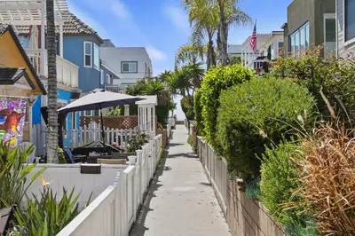 a sidewalk with a fence and trees and houses at Dream 2 Story Home! Steps to the Ocean, Private Patio, AC, Hot Tub & BBQ in San Diego