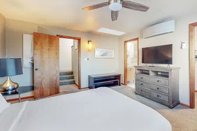 a bedroom with a white bed and a television at Dream 2 Story Home! Steps to the Ocean, Private Patio, AC, Hot Tub & BBQ in San Diego
