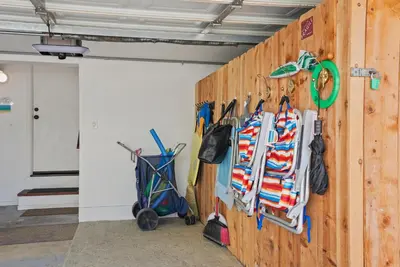 a wall with a bunch of umbrellas hanging on it at Dream 2 Story Home! Steps to the Ocean, Private Patio, AC, Hot Tub & BBQ in San Diego