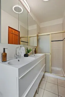 a white bathroom with a sink and a shower at Dream 2 Story Home! Steps to the Ocean, Private Patio, AC, Hot Tub & BBQ in San Diego