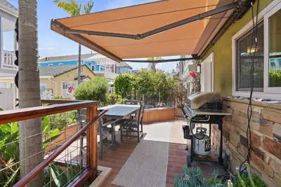 a patio with a table and a grill at Dream 2 Story Home! Steps to the Ocean, Private Patio, AC, Hot Tub & BBQ in San Diego