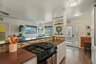 a kitchen with a stove and a counter top at Dream 2 Story Home! Steps to the Ocean, Private Patio, AC, Hot Tub & BBQ in San Diego
