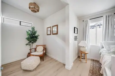 a white bedroom with a bed and a chair at NEW Boho-Beach House in San Diego