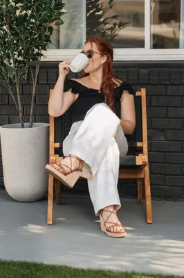a woman sitting in a chair drinking a cup of coffee at NEW Boho-Beach House in San Diego