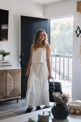 a woman in a white dress standing in a room at BoHo Beach House Walk to the Sand in San Diego