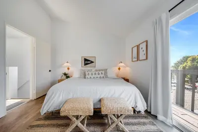 a bedroom with a bed and a large window at Boho Beach Bungalow Walk to the Beach in San Diego