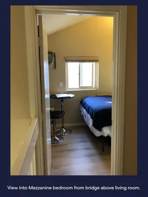 a room with a bed and a table and a window at Ocean Front Beauty right above Best Beach in Mission Beach, San Diego! in San Diego