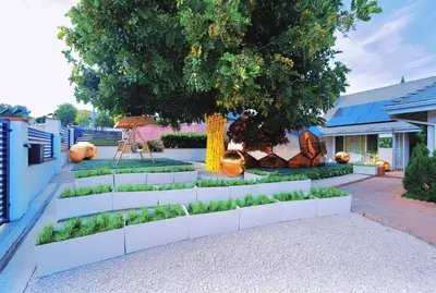 a garden with a white retaining wall and a tree at Casa de Bloom Venue - Your Perfect Event Space in San Diego