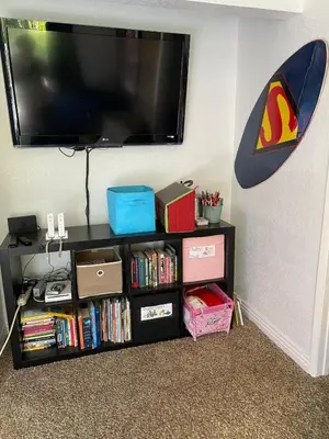 a black book shelf with a flat screen tv on a wall at Tropical retreat for whole family Fresh eggs Made to Entertain in Carlsbad