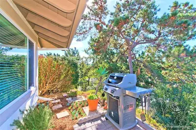 a barbecue on a patio next to a house at Viewpoint Villa - VILLA105 in Solana Beach