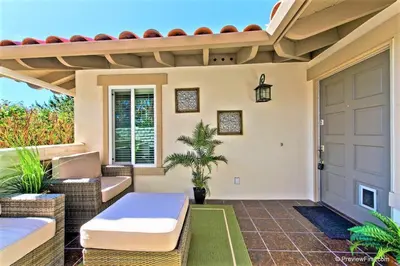 a patio with a door and chairs and a plant at Viewpoint Villa - VILLA105 in Solana Beach