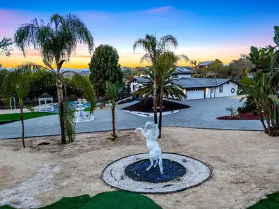 a statue of a dog standing on a circle in front of a house at The Grand Vista Getaway in Vista