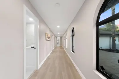 a hallway of a house with white walls and a window at The Grand Vista Getaway in Vista