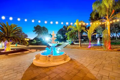 a fountain in a park at night with lights at The Grand Vista Getaway in Vista