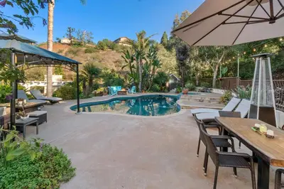 a patio with an umbrella and a swimming pool at Buena Creek Refuge - Family Resort Destination - Secure and Private - in Vista