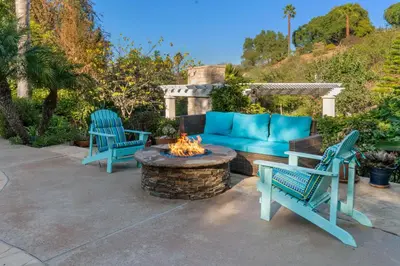 a patio with two blue chairs and a fire pit at Buena Creek Refuge - Family Resort Destination - Secure and Private - in Vista