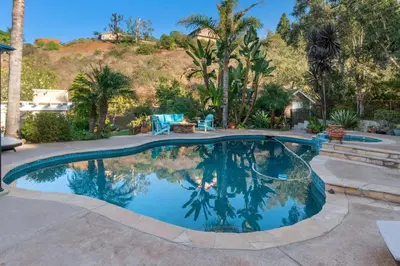 a swimming pool in a yard with palm trees at Buena Creek Refuge - Family Resort Destination - Secure and Private - in Vista