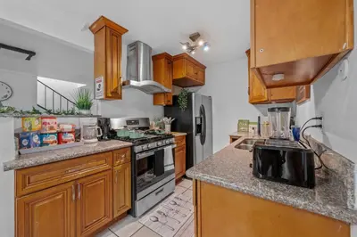 a kitchen with wooden cabinets and a stove top oven at Entire Private Home with 4 Bedrooms 2 Bathrooms, Garage & Gated Yard, Near San Diego Gaslamp, Beach, Available Now in National City