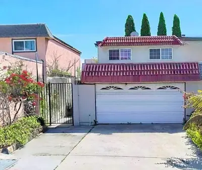 a house with a white garage with a gate at Entire Private Home with 4 Bedrooms 2 Bathrooms, Garage & Gated Yard, Near San Diego Gaslamp, Beach, Available Now in National City