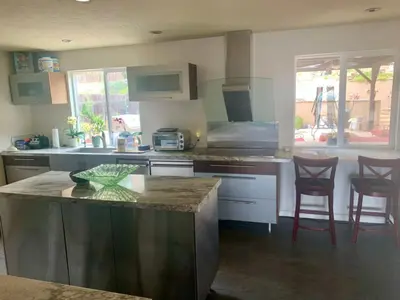 a kitchen with a counter and two chairs in it at Rooms in Bay Park, San Diego in San Diego