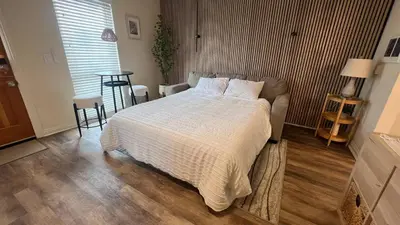 a bedroom with a bed and a table and a window at 2 Bdrm Condo + Parking in Heart of Mission Beach! in San Diego