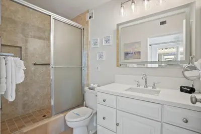 a bathroom with a toilet and a sink and a shower at Oceanfront Paradise with Sunset Balcony, Pool, Spa, Beach Access and Parking in San Diego
