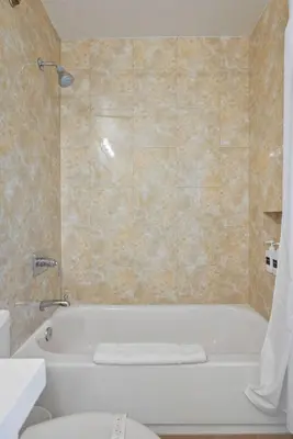 a bathroom with a white tub and a toilet at Oceanfront Paradise with Sunset Balcony, Pool, Spa, Beach Access and Parking in San Diego