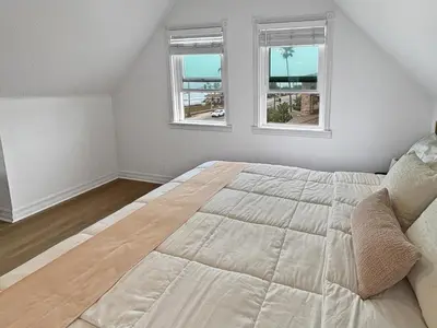 a bedroom with a large bed with two windows at F-75 Terramar Cliffs in Carlsbad
