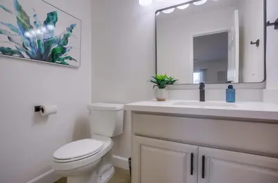 a bathroom with a toilet and a sink with a mirror at F-78 Seaside Escape in Encinitas