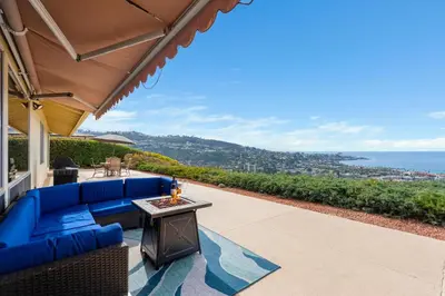 a blue couch on a patio with a view of the ocean at La Jolla Shores Views in San Diego
