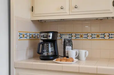 a coffee maker on a counter with a plate of food at La Jolla Shores Views in San Diego