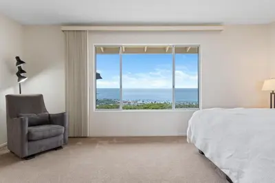 a bedroom with a bed and a chair and a large window at La Jolla Shores Views in San Diego