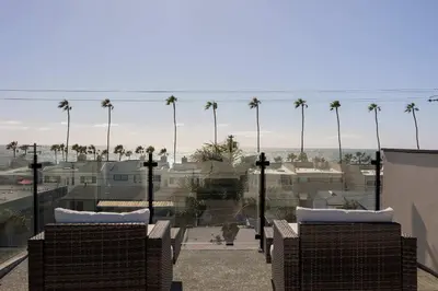 a view of a city with palm trees in the background at Walk to the Beach & Pier Ocean View Roof Deck in Oceanside