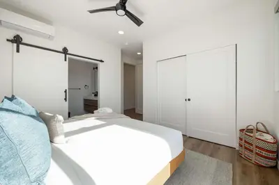 a white bedroom with a bed and a ceiling fan at Walk to the Beach & Pier Ocean View Roof Deck in Oceanside