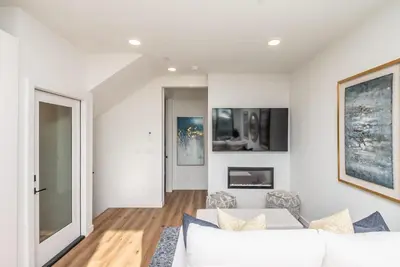 a living room with a white couch and a fireplace at Ocean View Roof Deck - Walk to the Beach & Pier in Oceanside