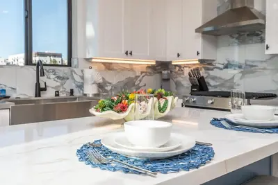 a kitchen with two plates and a bowl of fruit at Ocean View Roof Deck - Walk to the Beach & Pier in Oceanside