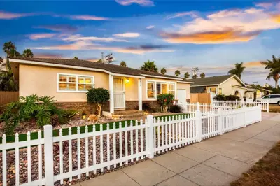a white picket fence in front of a house at Walk to the Beach Private Backyard and Fire Pit in Oceanside