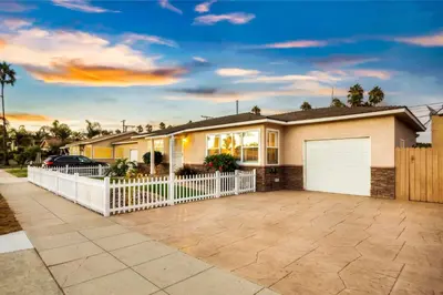 a house with a white fence and a driveway at Walk to the Beach Private Backyard and Fire Pit in Oceanside