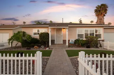 a white fence in front of a house at Walk to the Beach Private Backyard and Fire Pit in Oceanside