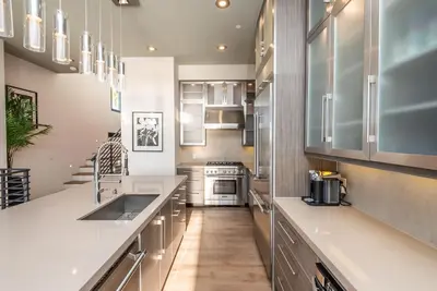 a kitchen with white cabinets and a counter top at Walk to the Beach Luxury Roof Deck Sunset View in Oceanside