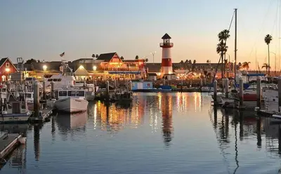 a marina with boats in the water with a lighthouse at Walk to the Beach Luxury Roof Deck Sunset View in Oceanside
