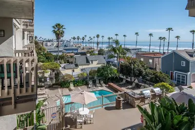 a view of the pool and the beach from a balcony of a resort at Steps to the Beach 2 Pools & Hot Tubs - A-204 in Oceanside