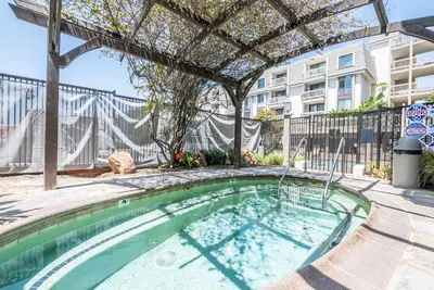 a swimming pool with a pergola next to a building at Panoramic Water Views - Steps to the Beach - F-2 in Oceanside