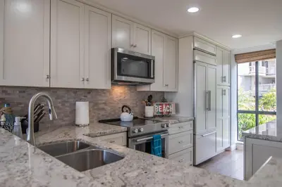 a kitchen with white cabinets and a sink at Panoramic Water Views - Steps to the Beach - F-2 in Oceanside