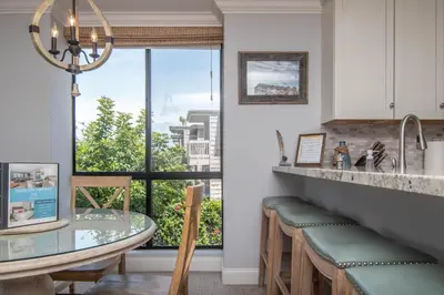 a kitchen with a counter with stools and a window at Panoramic Water Views - Steps to the Beach - F-2 in Oceanside