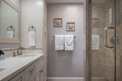 a bathroom with a sink and a shower with towels at Panoramic Water Views - Steps to the Beach - F-2 in Oceanside