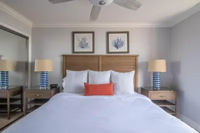 a bedroom with a large white bed with a red pillow at Panoramic Water Views - Steps to the Beach - F-2 in Oceanside