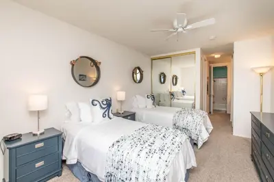 a bedroom with two beds and a mirror at Penthouse Ocean & Sunset Balcony Views - G-323 in Oceanside