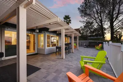 a patio with green chairs and a house at Hot Tub with A View and Large Back Deck & Game Room in Poway