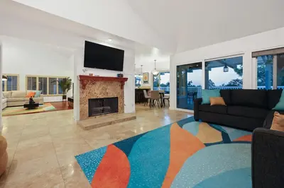 a living room with a couch and a fireplace at Hot Tub with A View and Large Back Deck & Game Room in Poway